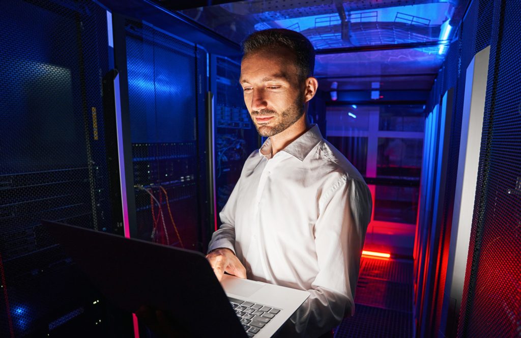 Man with a Laptop in a Server Room